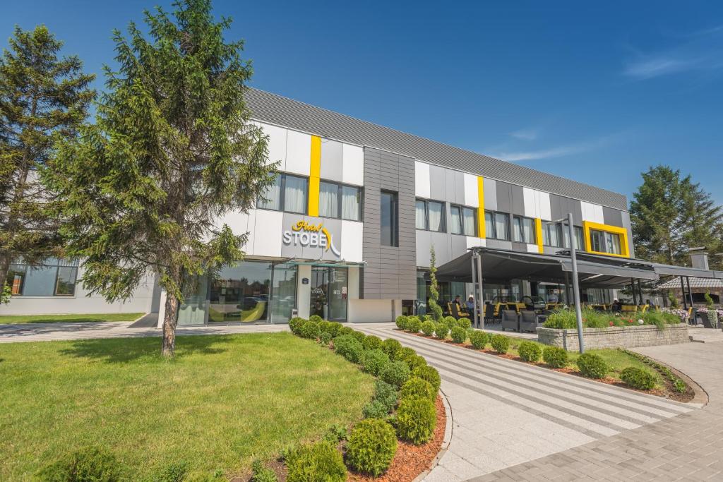 an office building with a tree in front of it at Hotel Stobex Loznica in Loznica