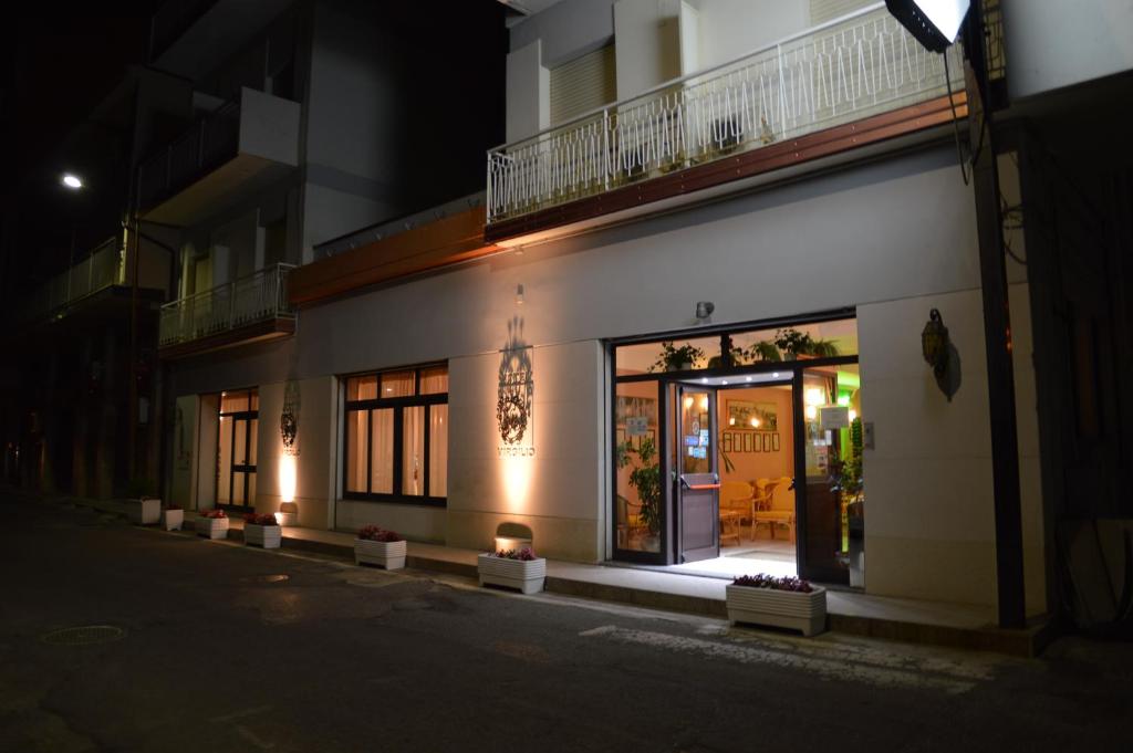 ein Gebäude mit einer beleuchteten Eingangstür in der Nacht in der Unterkunft Hotel Virgilio in Tropea