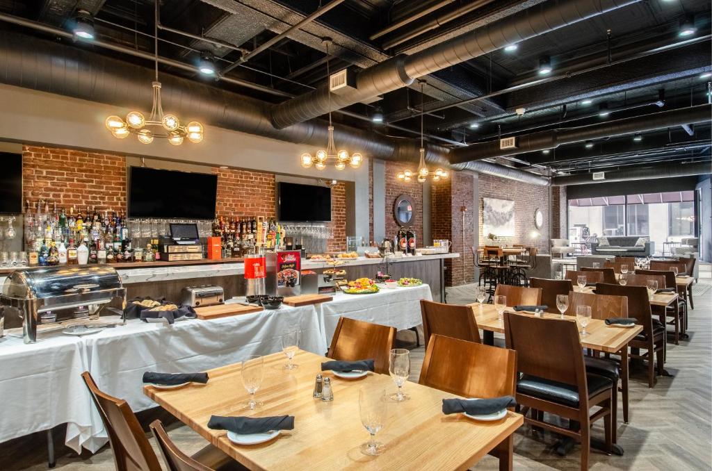 a dining room with tables and a bar at New Bedford Harbor Hotel, Ascend Hotel Collection in New Bedford