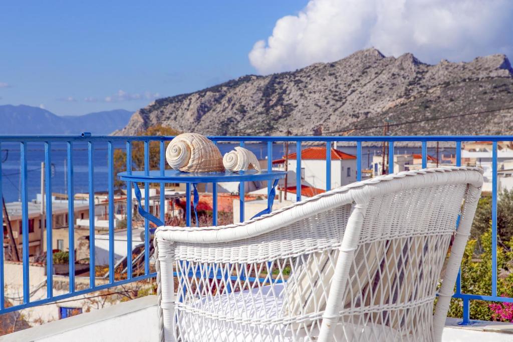 uma cadeira de vime branca sentada numa varanda com vista para o oceano em Aeginia 1- Breathtaking sea view house in Perdika em Perdika