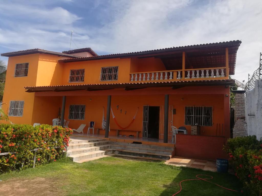 een oranje huis met een gazon ervoor bij Casa Majorlandia in Majorlândia