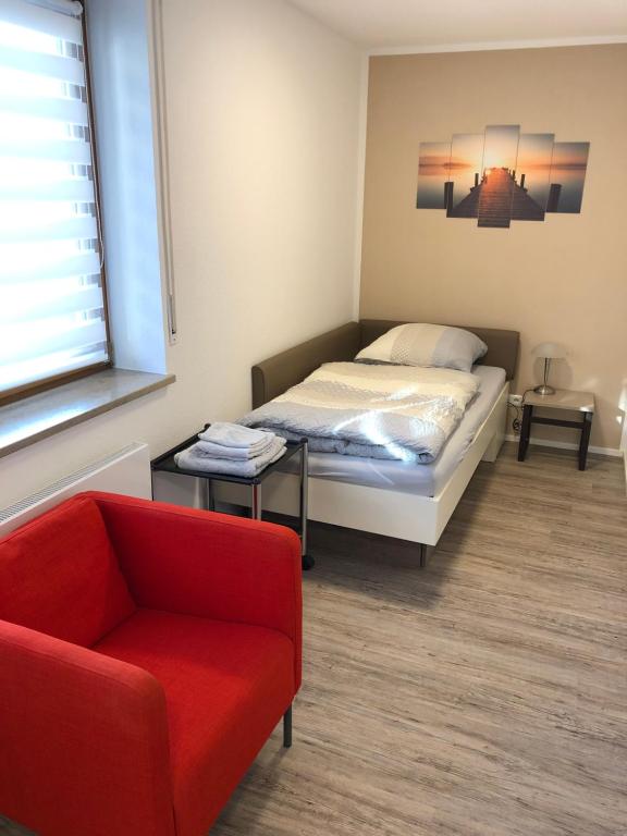 1 dormitorio con 1 cama y 1 sofá rojo en Apartment nahe Siemens Campus en Erlangen