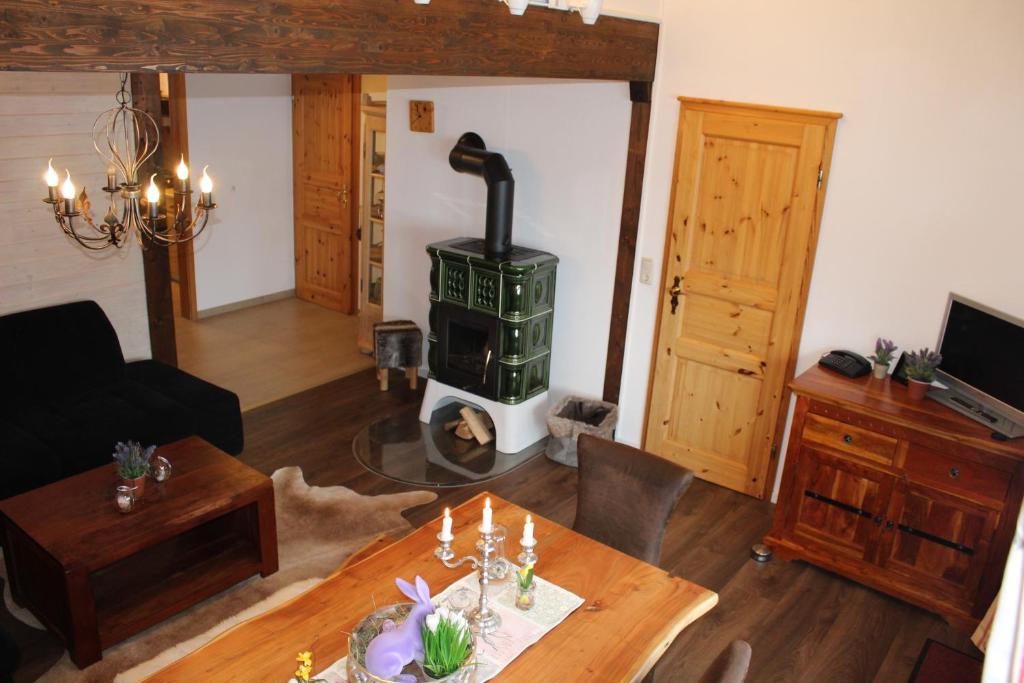 Ferienwohnung im Landhausstil في ميسين-فيلامس: غرفة معيشة مع موقد خشبي في غرفة