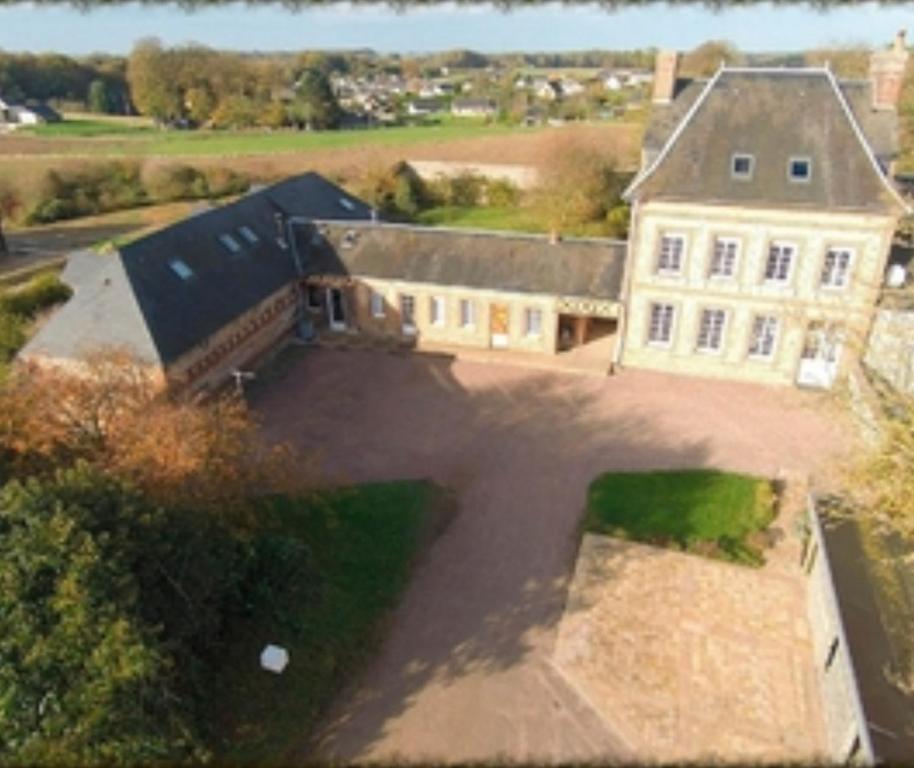 Les Chambres de Thiergeville في Thiergeville: اطلالة هوائية على منزل كبير مع ممر كبير