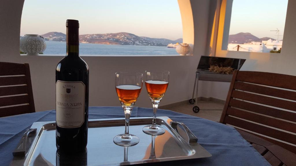 una bottiglia di vino e due bicchieri su un tavolo di Port View House a Parasporos