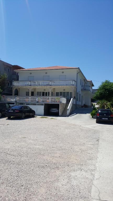 a large building with cars parked in a parking lot at Anka Bunić in Rab