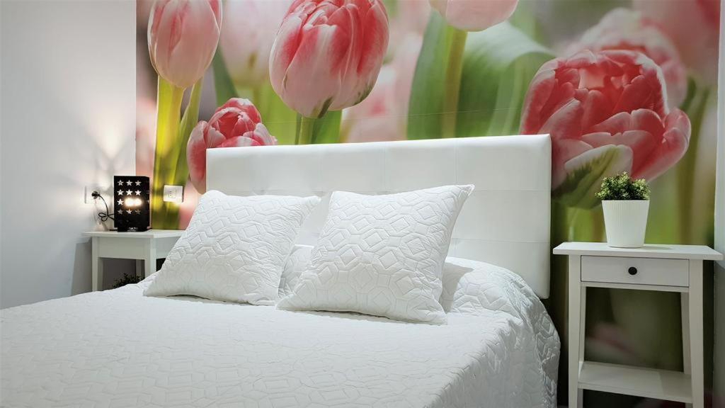 a bedroom with a white bed with pink tulips at Home Sweet Home in Arona