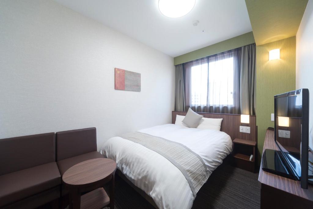 Postel nebo postele na pokoji v ubytování Myoujin-no-Yu Dormy Inn Premium Kanda