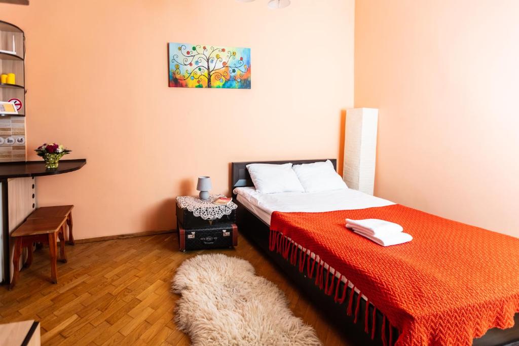a bedroom with a bed with a red blanket at Smart Lwow House in Lviv