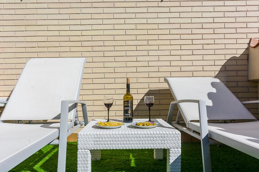 a table with two chairs and a bottle of wine at Apartamento Montferrant in Blanes