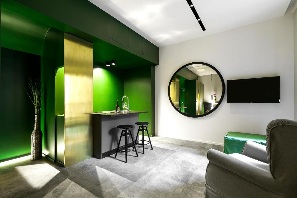 ein Wohnzimmer mit grünen Wänden und einem Spiegel in der Unterkunft Etruscan Luxury Suites in Rom