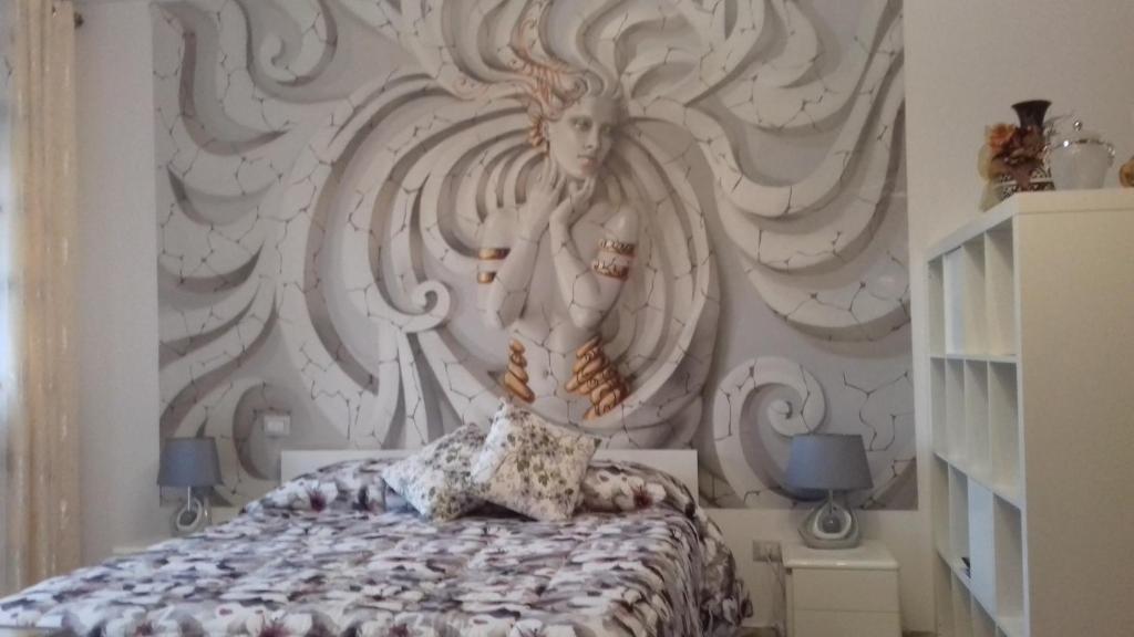 ein Schlafzimmer mit einem Wandbild einer Frau in der Unterkunft Via Cortonese n. 27 in Perugia