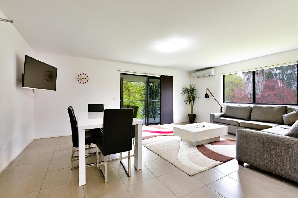 uma sala de estar com uma mesa e um sofá em Apex Park Holiday Apartments em Wangaratta