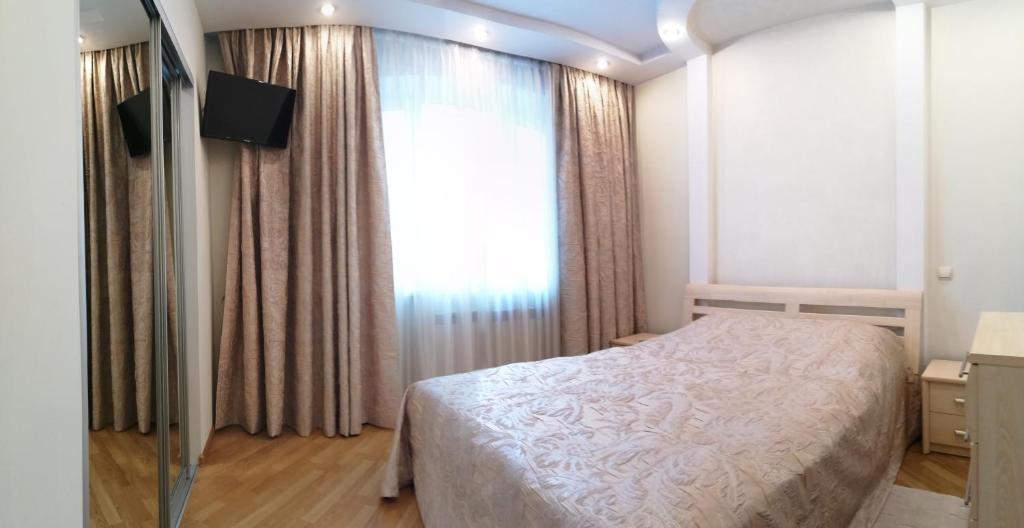 a bedroom with a bed and a large window at Big Apartment in Rivne center in Rivne