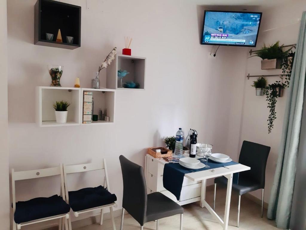 een eetkamer met een witte tafel en stoelen bij La Joya de la Caleta. A 60 mts playa. in Cádiz