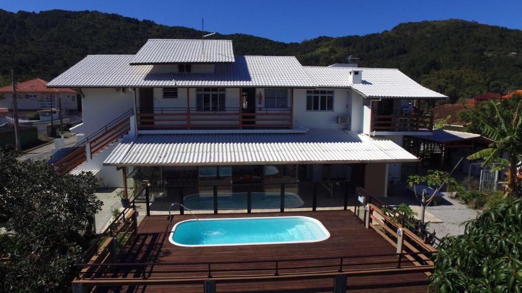 una casa con piscina frente a ella en Hospedagem Engenho Fortaleza, en Florianópolis