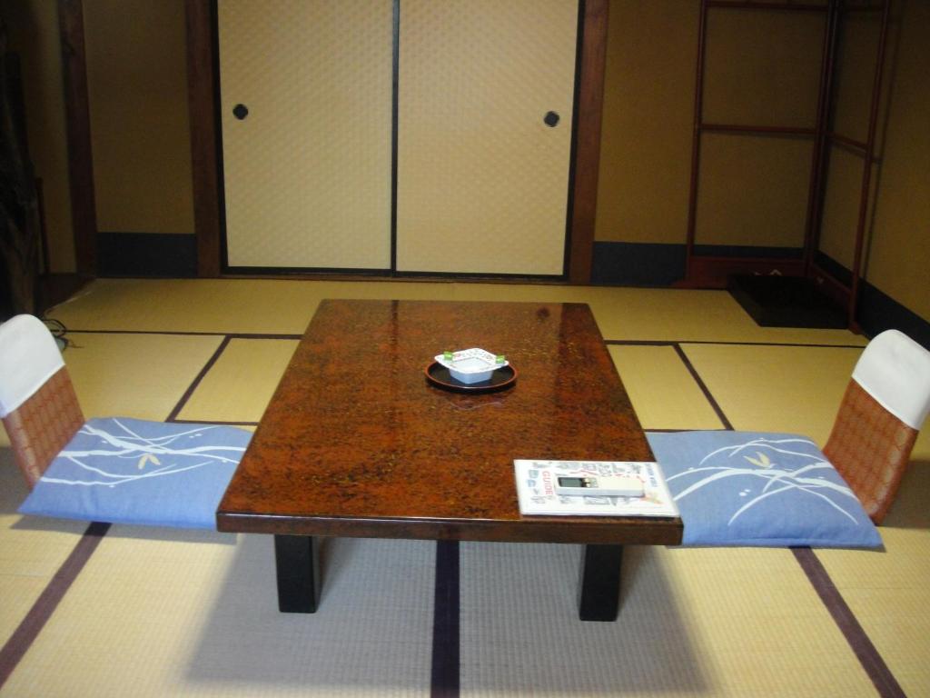 une table en bois avec deux chaises et un papier sur elle dans l'établissement Kurhaus Ishibashi Ryokan, à Shimoda 42 autres photos