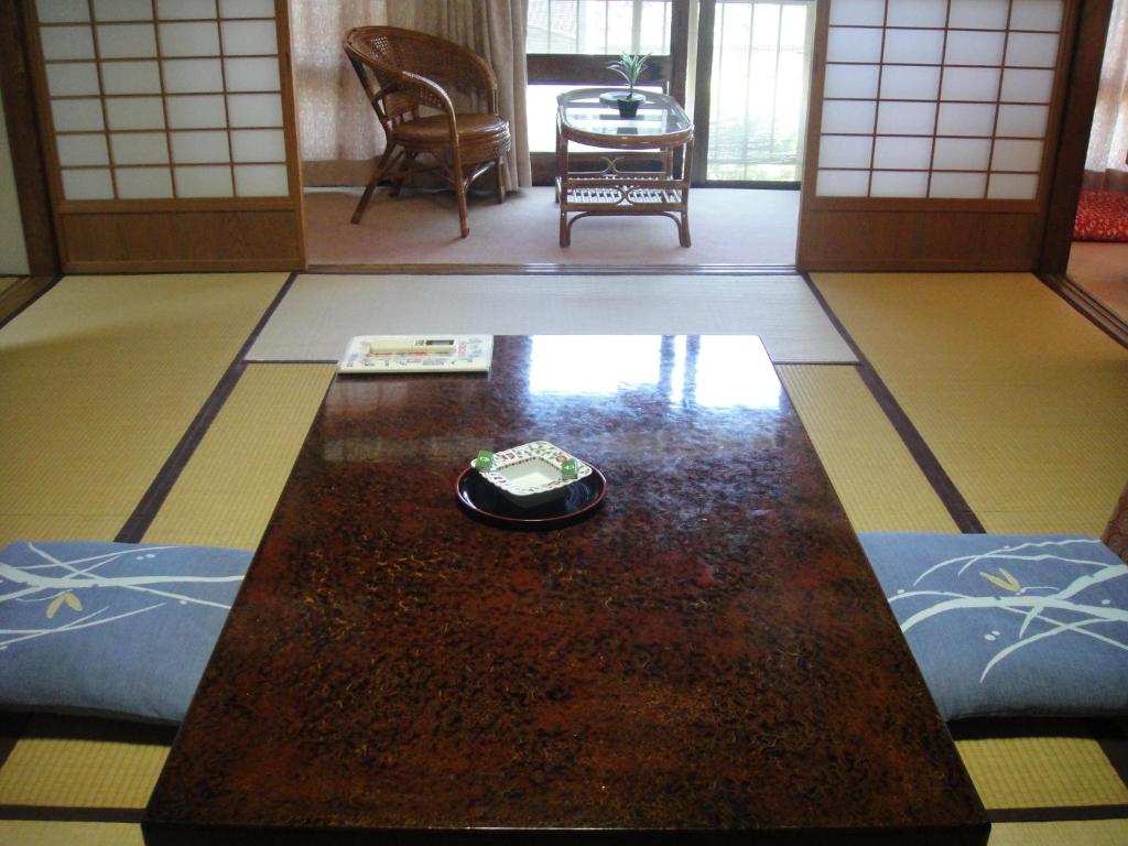 une table avec un téléphone portable posé dessus dans l'établissement Kurhaus Ishibashi Ryokan, à Shimoda