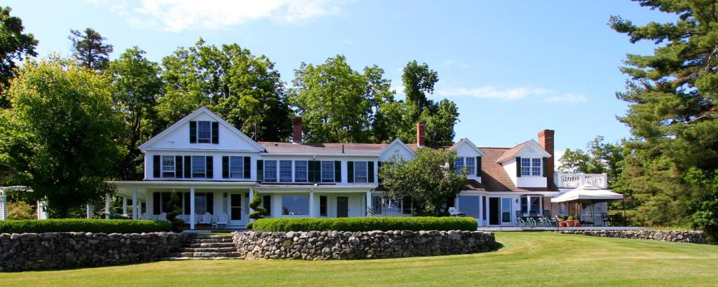 a white house with a stone wall at Maguire House Bed and Breakfast in Ashburnham