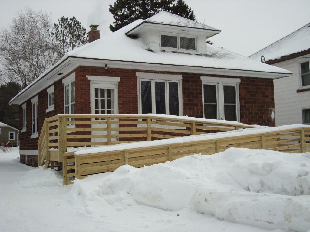 a house with a wooden fence in the snow at Active Lakeview Escape in Montreal