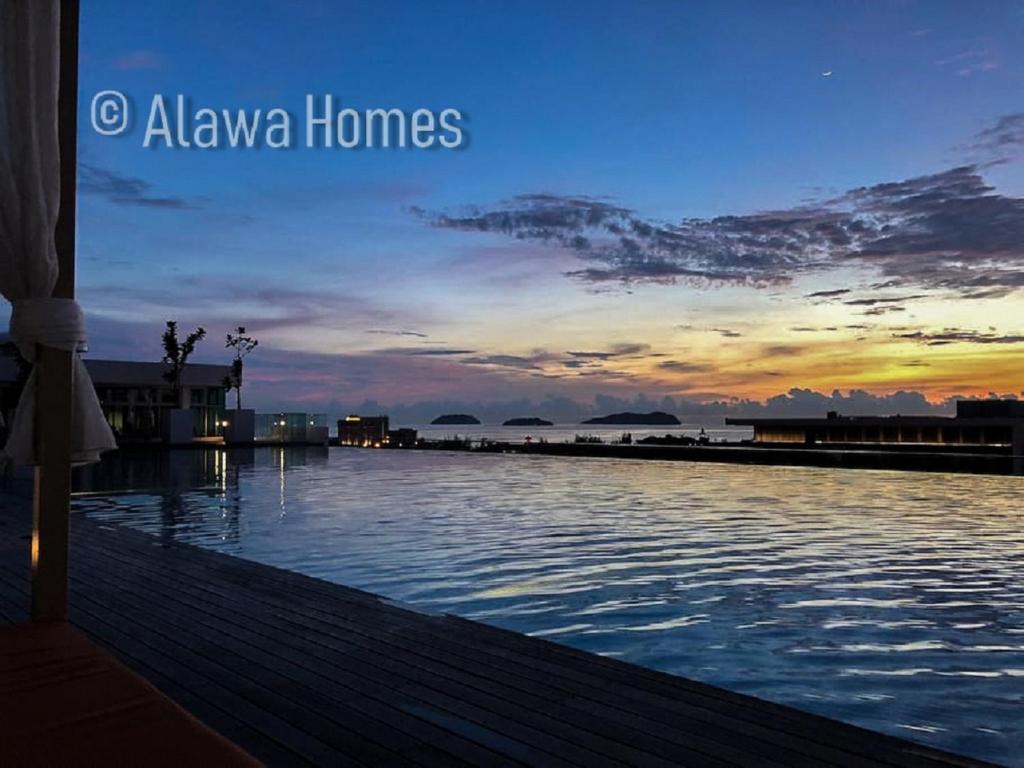a view of a swimming pool at sunset at Sutera Avenue by Alawa Homes Kota Kinabalu in Kota Kinabalu