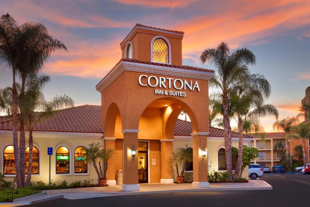 una posada corona y un edificio de suites con palmeras en Cortona Inn and Suites Anaheim Resort, en Anaheim