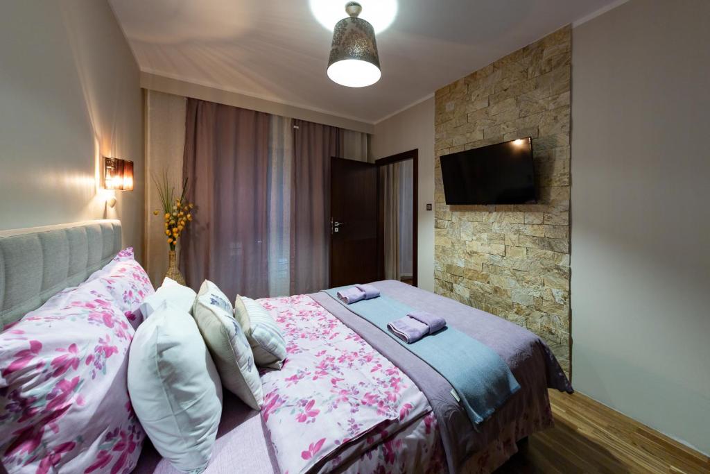 a bedroom with a bed and a flat screen tv at Apartament MODERNA Francuska Park in Katowice