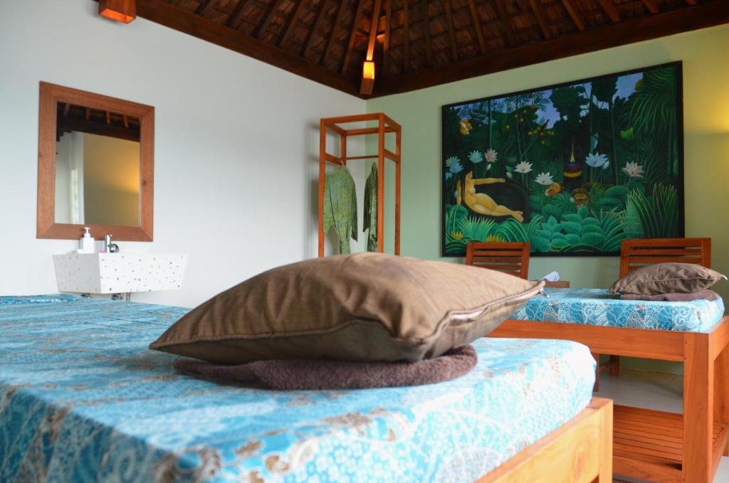 a bedroom with a bed and a painting on the wall at Cocotinos Sekotong Lombok in Sekotong