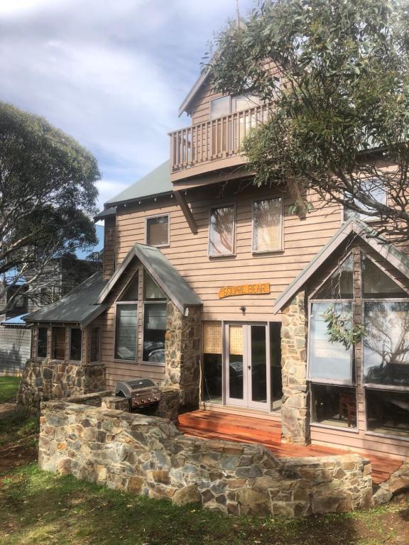 a large house with a stone wall at Square Bear in Dinner Plain