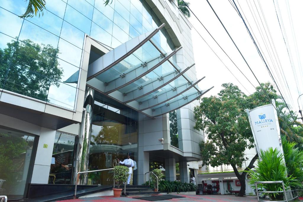 a large glass building with a person in front of it at Maurya Rajadhani in Trivandrum