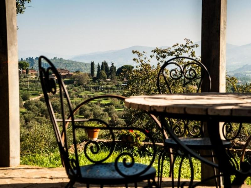 a table and chairs with a view of a field at Podere Scaluccia in Impruneta