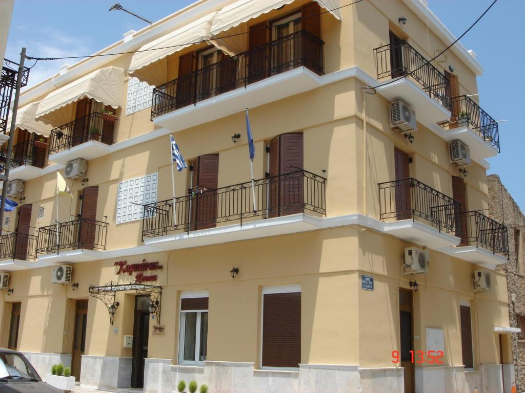 a yellow building with balconies on the side of it at Kabanis Rooms in Ermoupoli