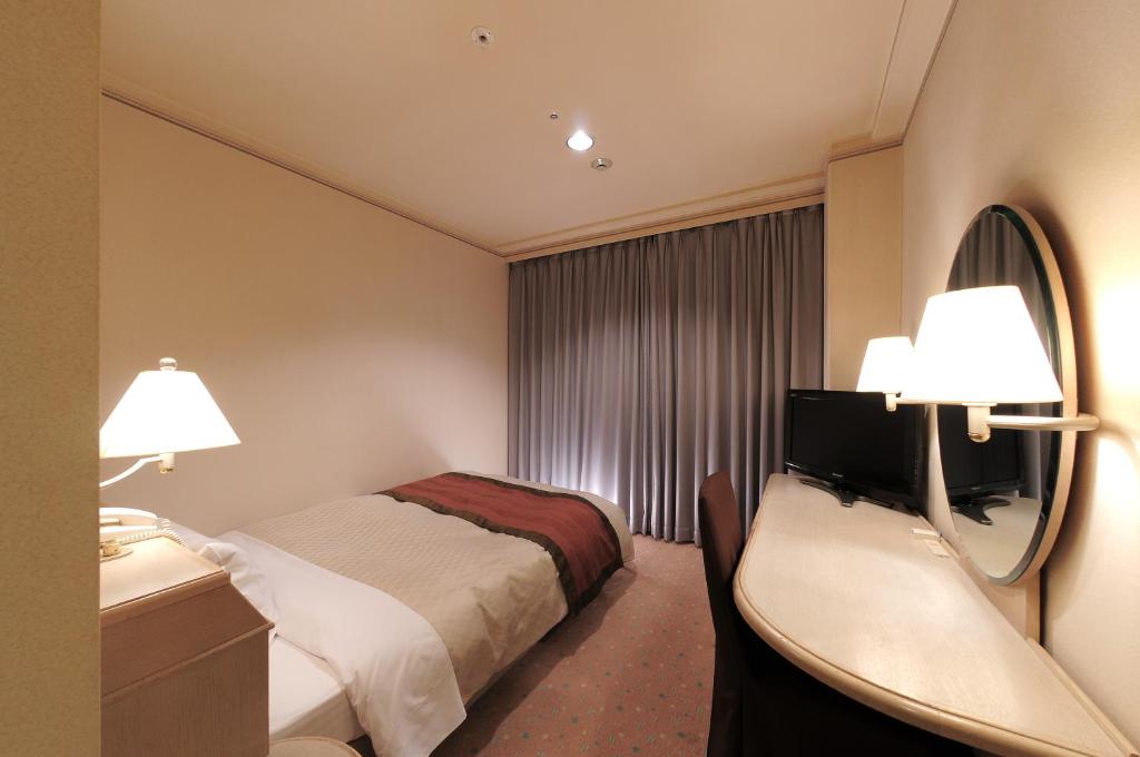 Postel nebo postele na pokoji v ubytování Takarazuka Washington Hotel