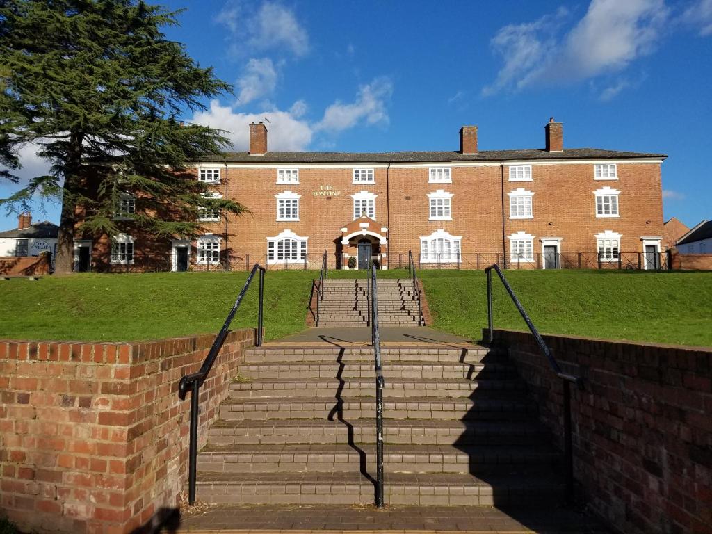 Un grand bâtiment en briques avec des escaliers se trouve juste devant. dans l'établissement JJ's "Gin Palace" luxury riverside town house, à Stourport