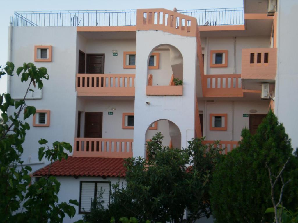 un edificio de apartamentos con balcones y árboles en Pentari en Stalós