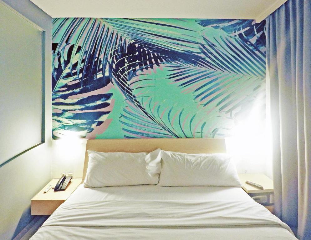 Postel nebo postele na pokoji v ubytování Liberta Hotel Kemang