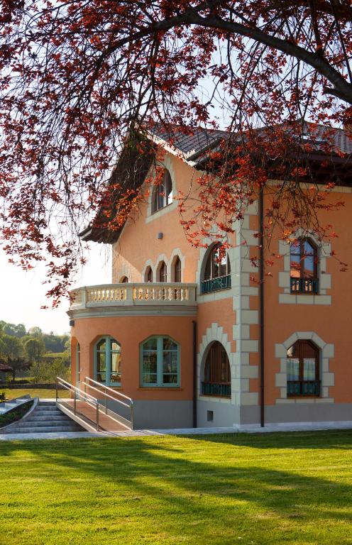 a large orange building with a grassy yard at La Casona del Viajante - Adults Only in Villabajo
