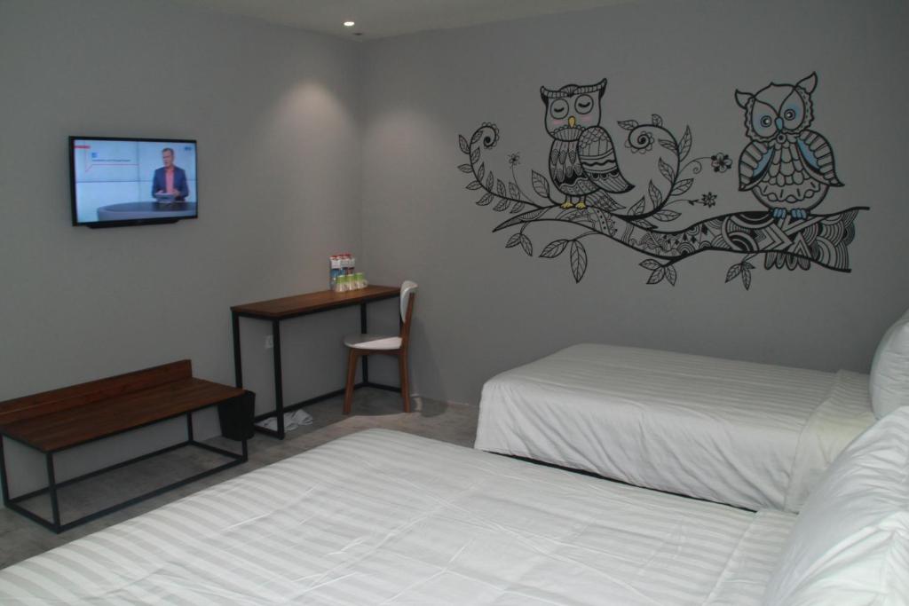 - une chambre avec 2 lits et une télévision murale dans l'établissement Nite & Day Surabaya - Kedungdoro, à Surabaya