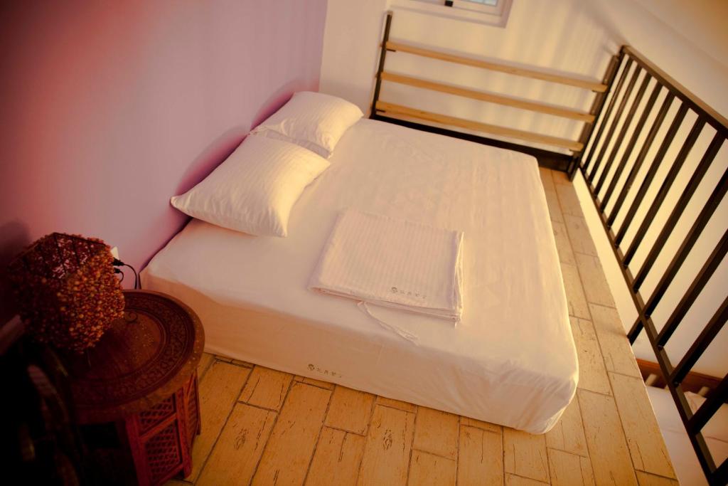 a bed with white sheets and pillows in a room at Alongs Garden in Hengchun South Gate