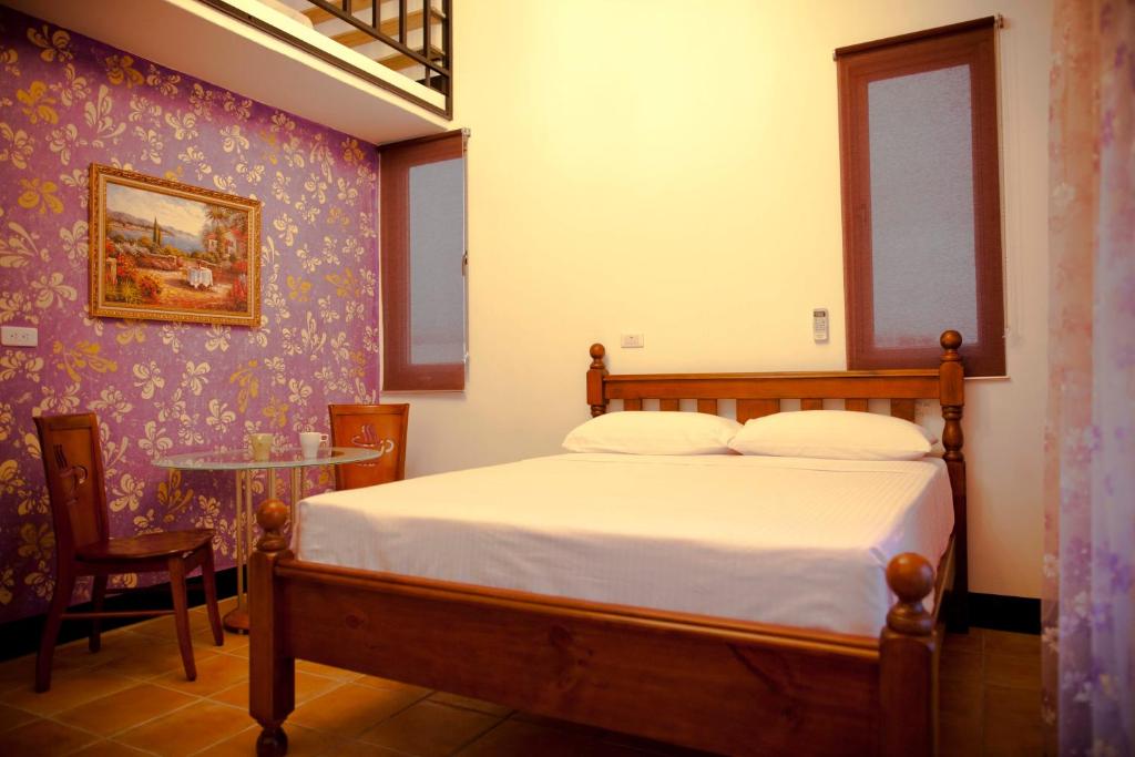 a bedroom with a bed and a table with a chair at Alongs Garden in Hengchun South Gate