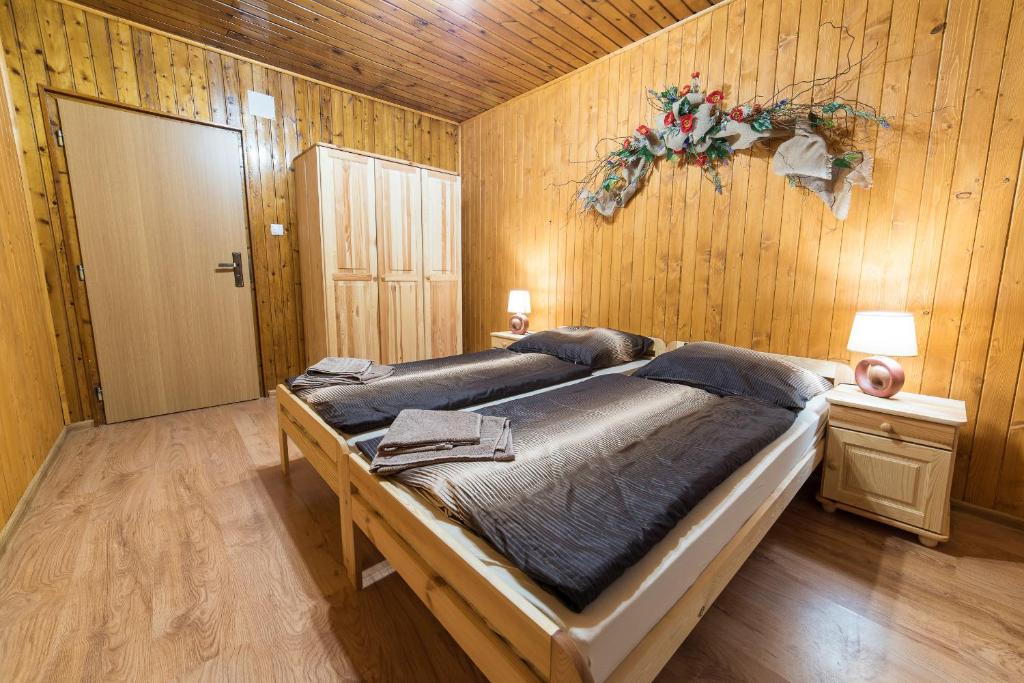 um quarto com uma cama grande numa parede de madeira em Apartmány Nízke Tatry - Krpáčovo em Dolná Lehota