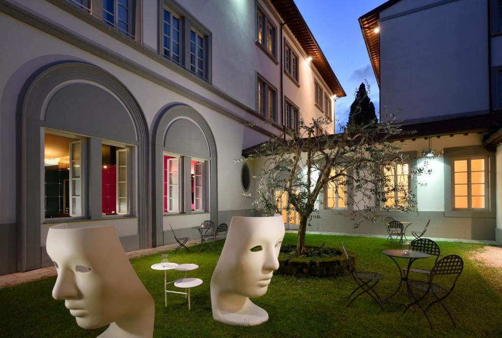 two white head statues in a yard next to a building at UNAHOTELS Vittoria Firenze in Florence