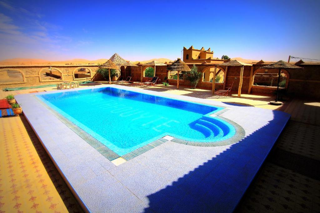 a swimming pool in the middle of a desert at Dar Tafouyte in Merzouga
