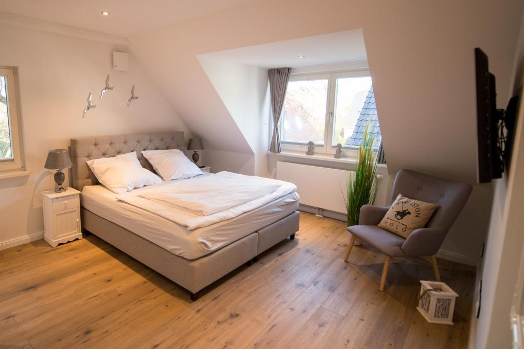 a bedroom with a bed and a chair at Abendsonne in Westerland