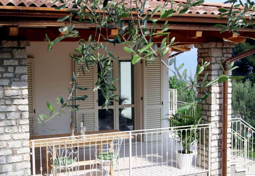 トスコラーノ・マデルノにあるVilla degli Uliviの植物のあるバルコニー付きの家