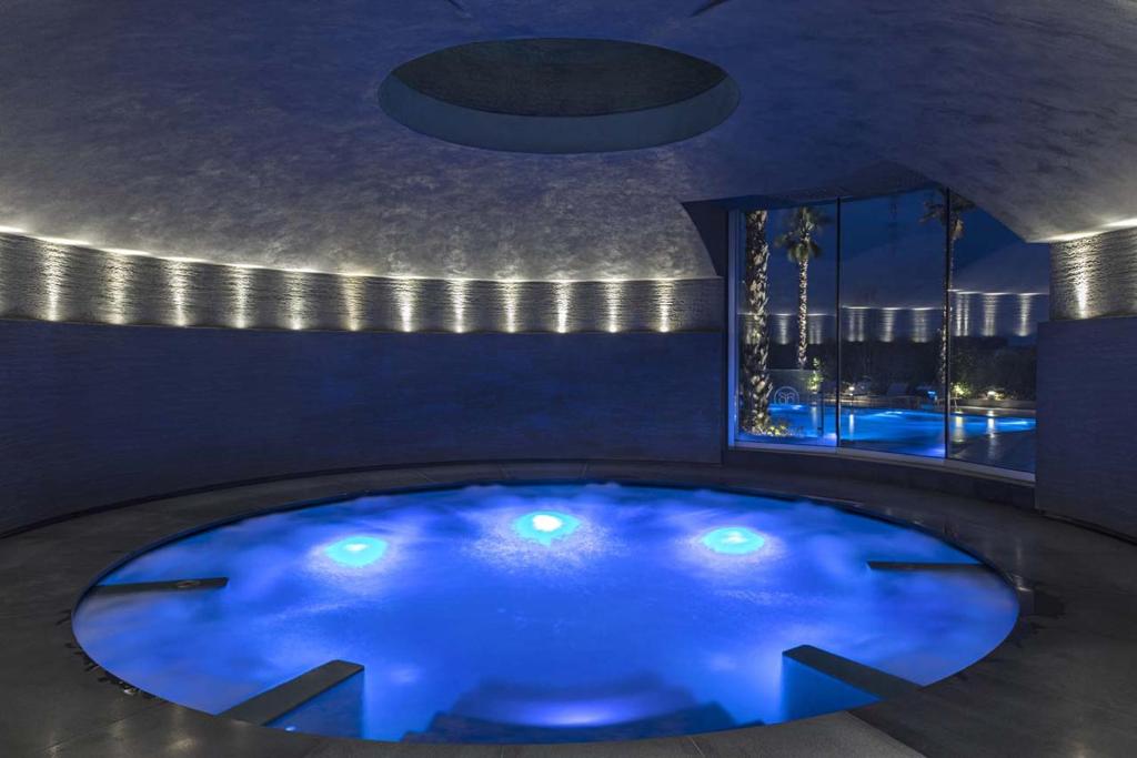Borgo San Barbato Resort Spa & Golf في Lavello: مسبح أزرق كبير مع أضواء في الغرفة