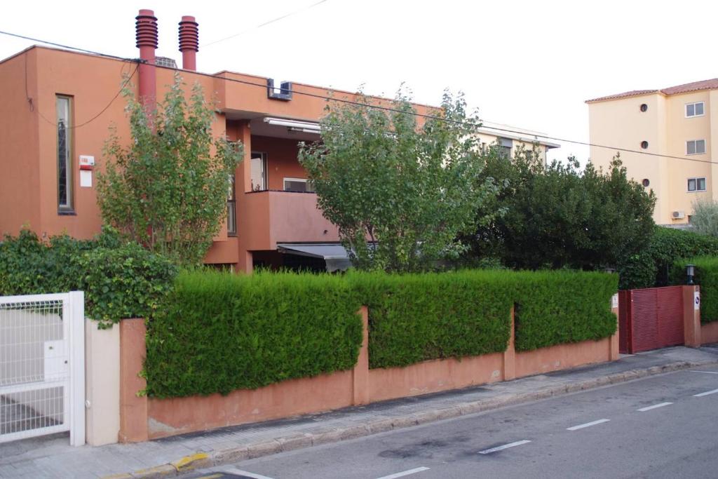 a hedge in front of a building next to a street at REFUGI DE MAR WITH PRIVATE SWIMMING POOL AND FREE WIFi in Hospitalet de l'Infant