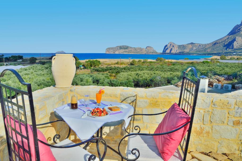 a table and chairs on a patio with a view of the ocean at Koukis House in Falasarna