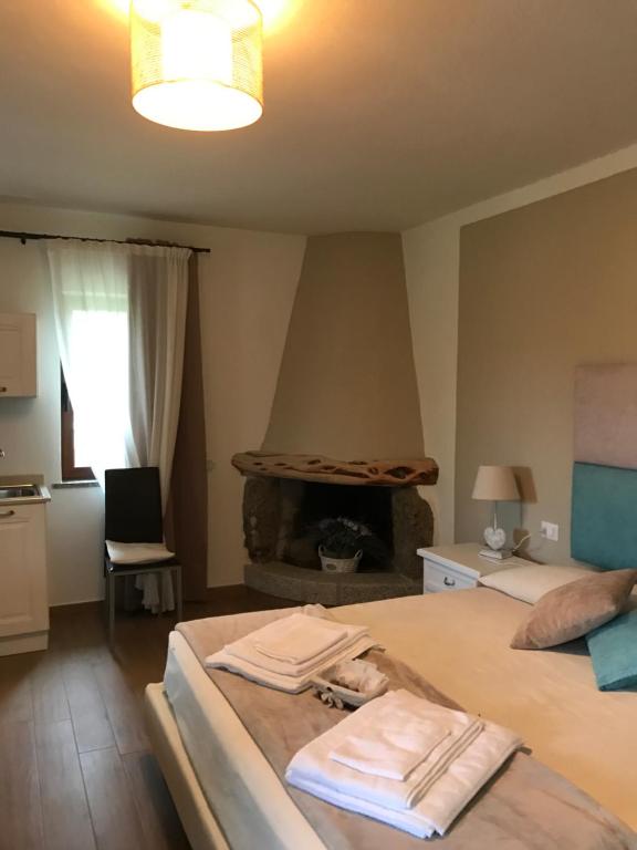 1 dormitorio con 2 camas y chimenea en Il Giardino di Daniela Apartments en San Teodoro