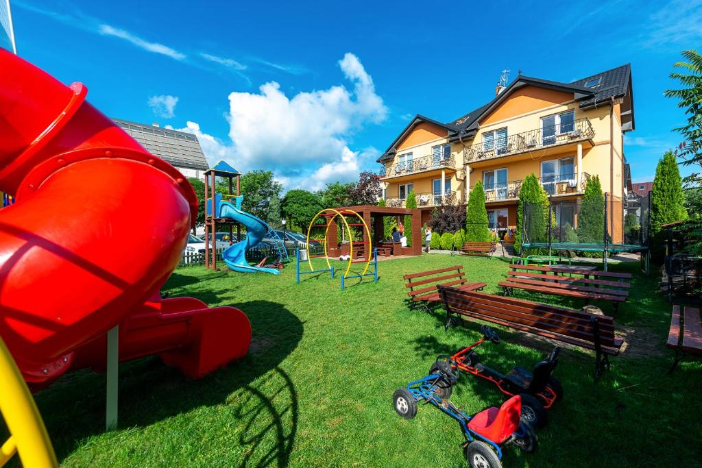 um parque com um parque infantil com escorrega e baloiços em Willa Nemo em Karwia